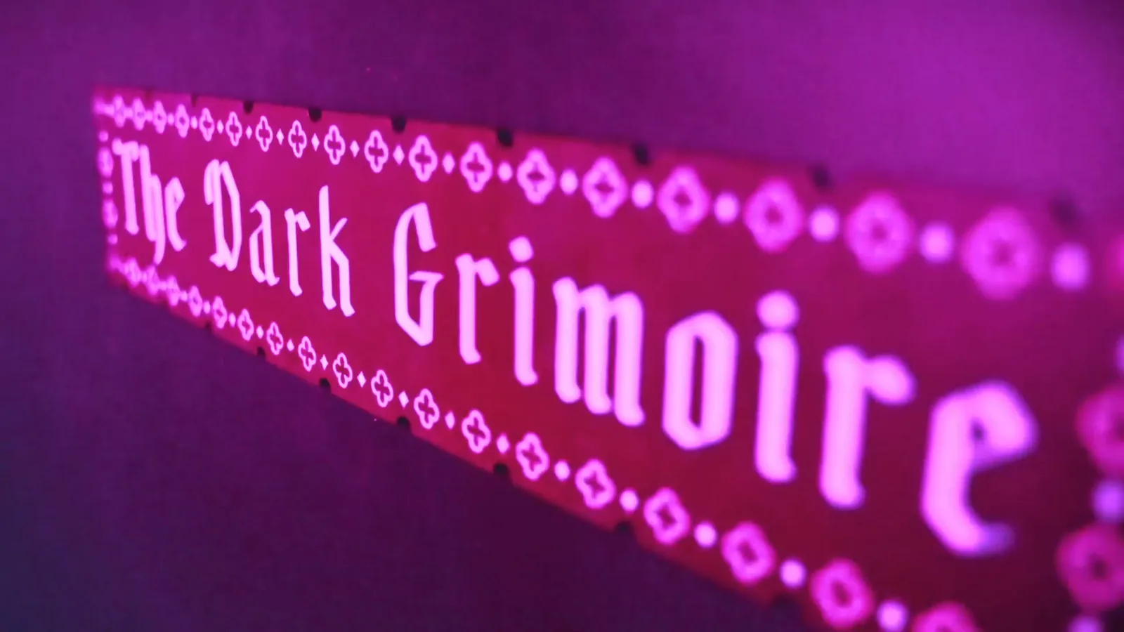 A glowing sign reading The Dark Grimoire inside The Wizard's Chamber